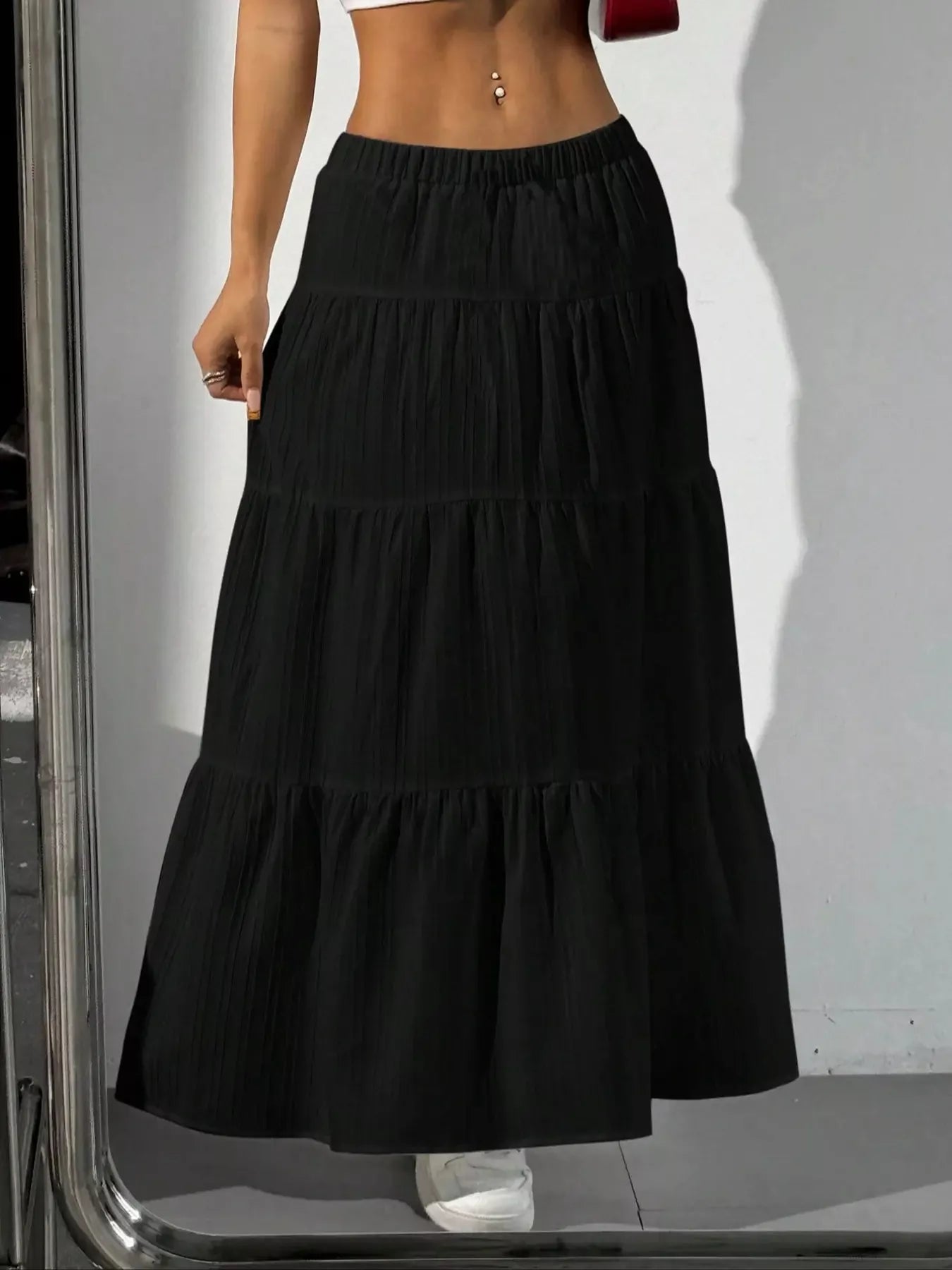 Black tiered maxi skirt with shadow on white wall