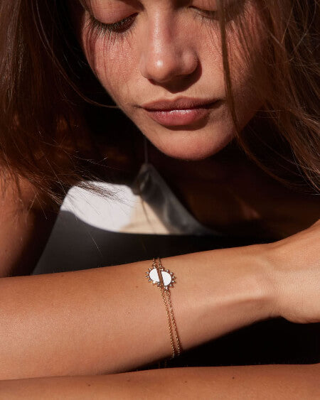 Close-up of a woman's arm wearing a delicate bracelet with a blurred background