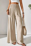 Beige Smocked Waist Wide Leg Pants with bag and white wall