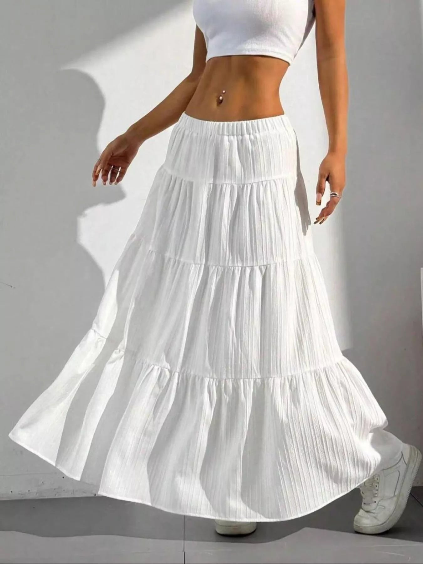 White tiered maxi skirt with shadow on white wall