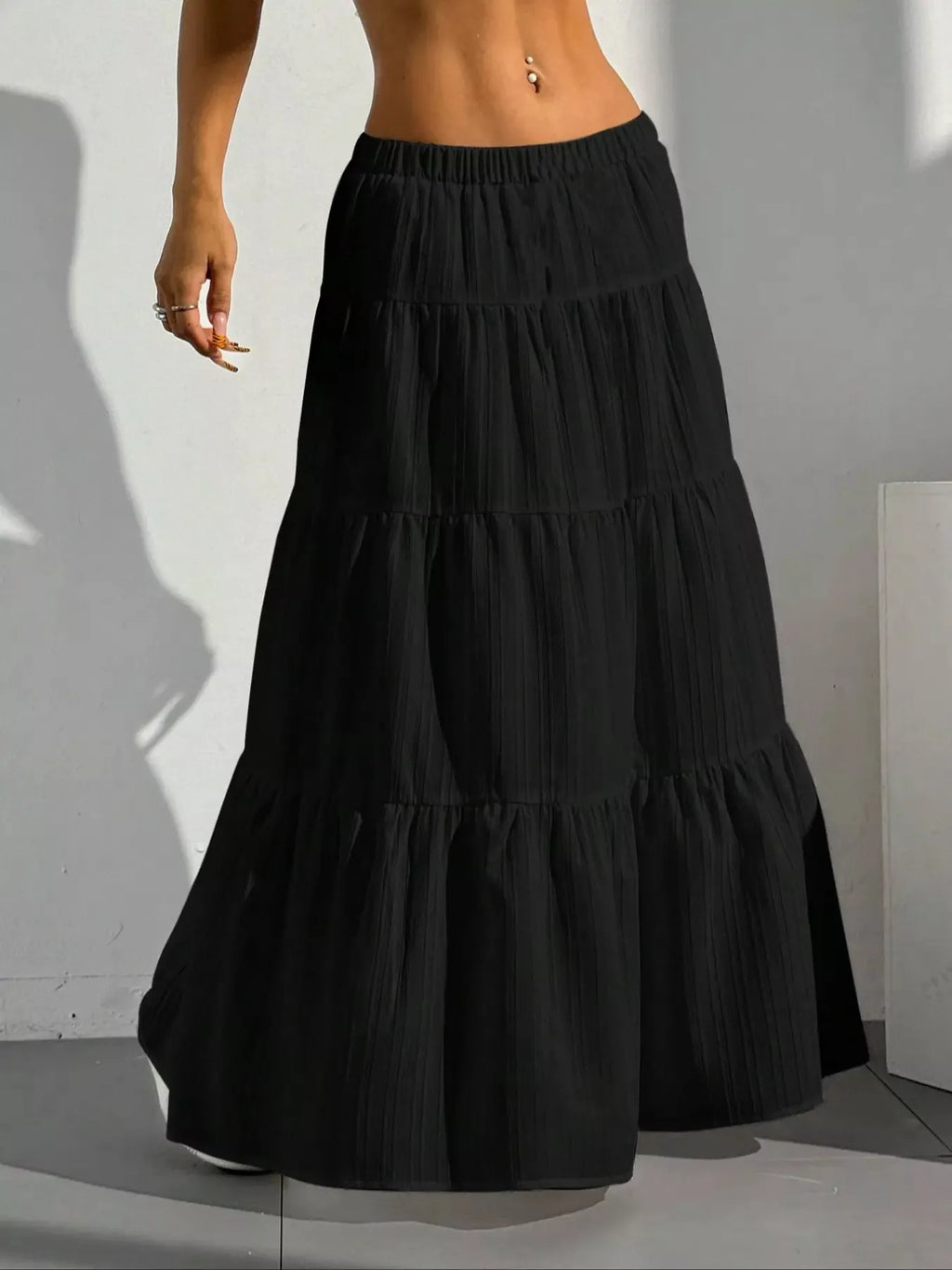 Black tiered maxi skirt with shadow on white wall
