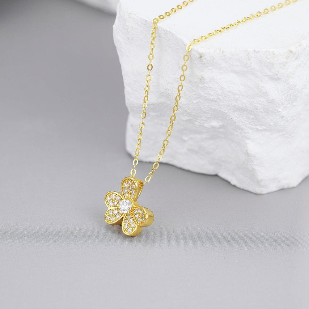 Side view of gold clover pendant necklace showing depth and sparkle