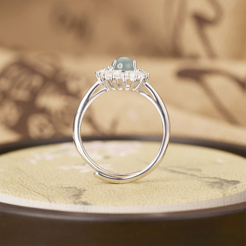 Silver ring with a gemstone on a textured surface