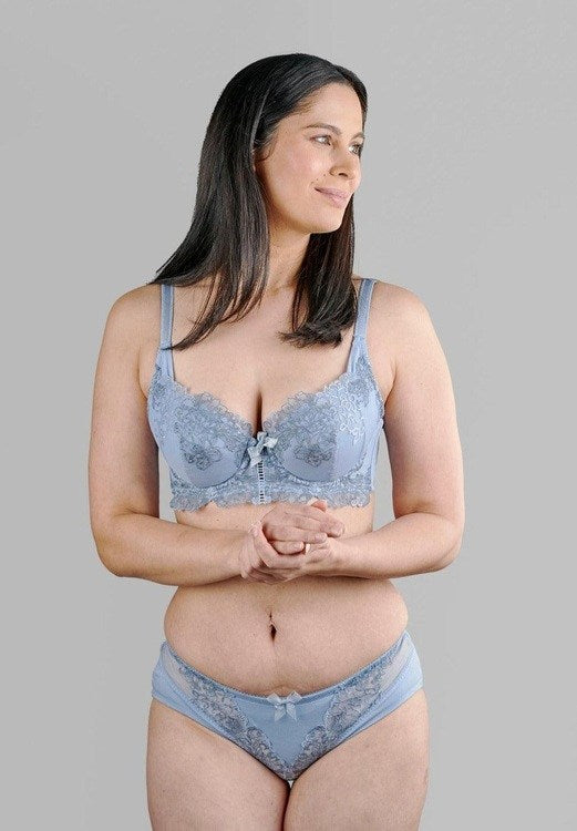 Woman wearing cornflower blue plunge bra and matching lace underwear set