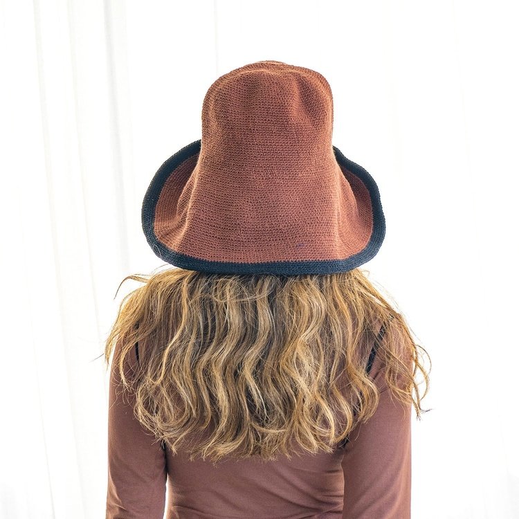 Dark brown crochet sun hat with black brim trim worn by woman