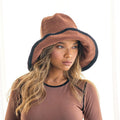 Front view of woman wearing dark brown crochet sun hat with black brim