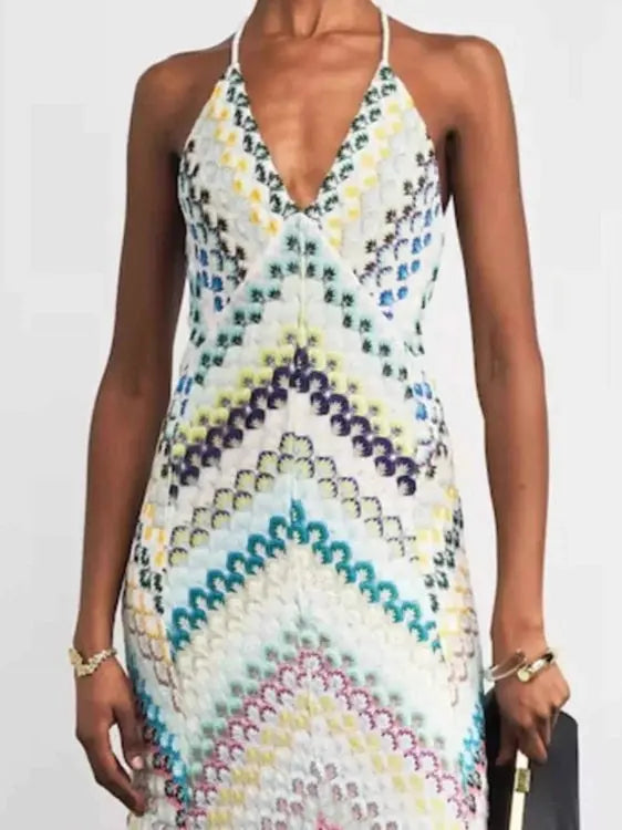 Woman wearing a colorful patterned dress on a plain background
