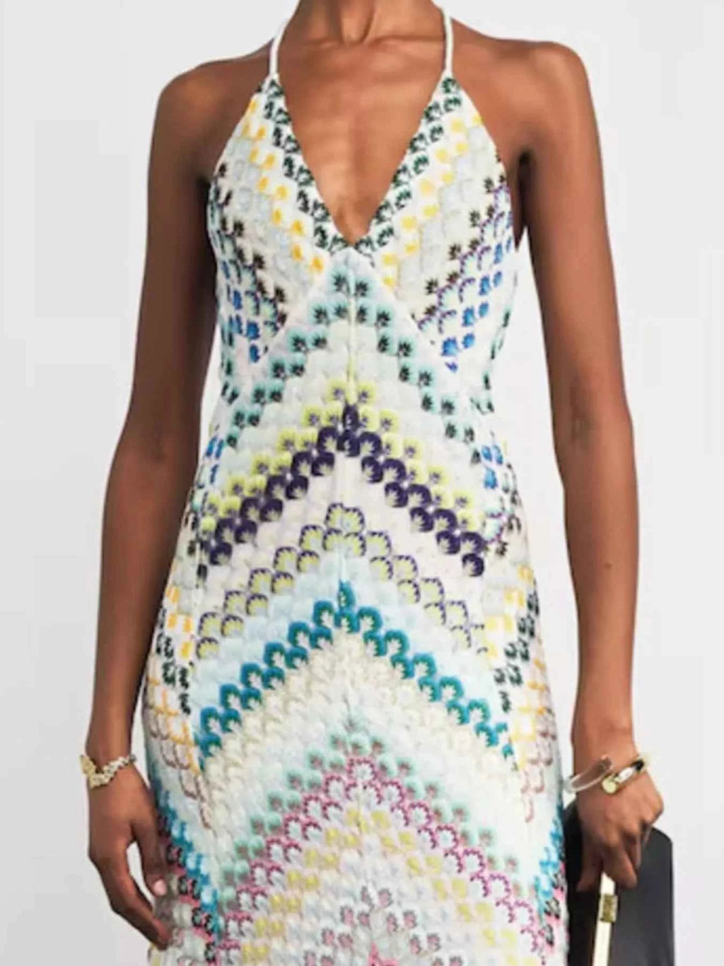 Woman wearing a colorful patterned dress on a plain background