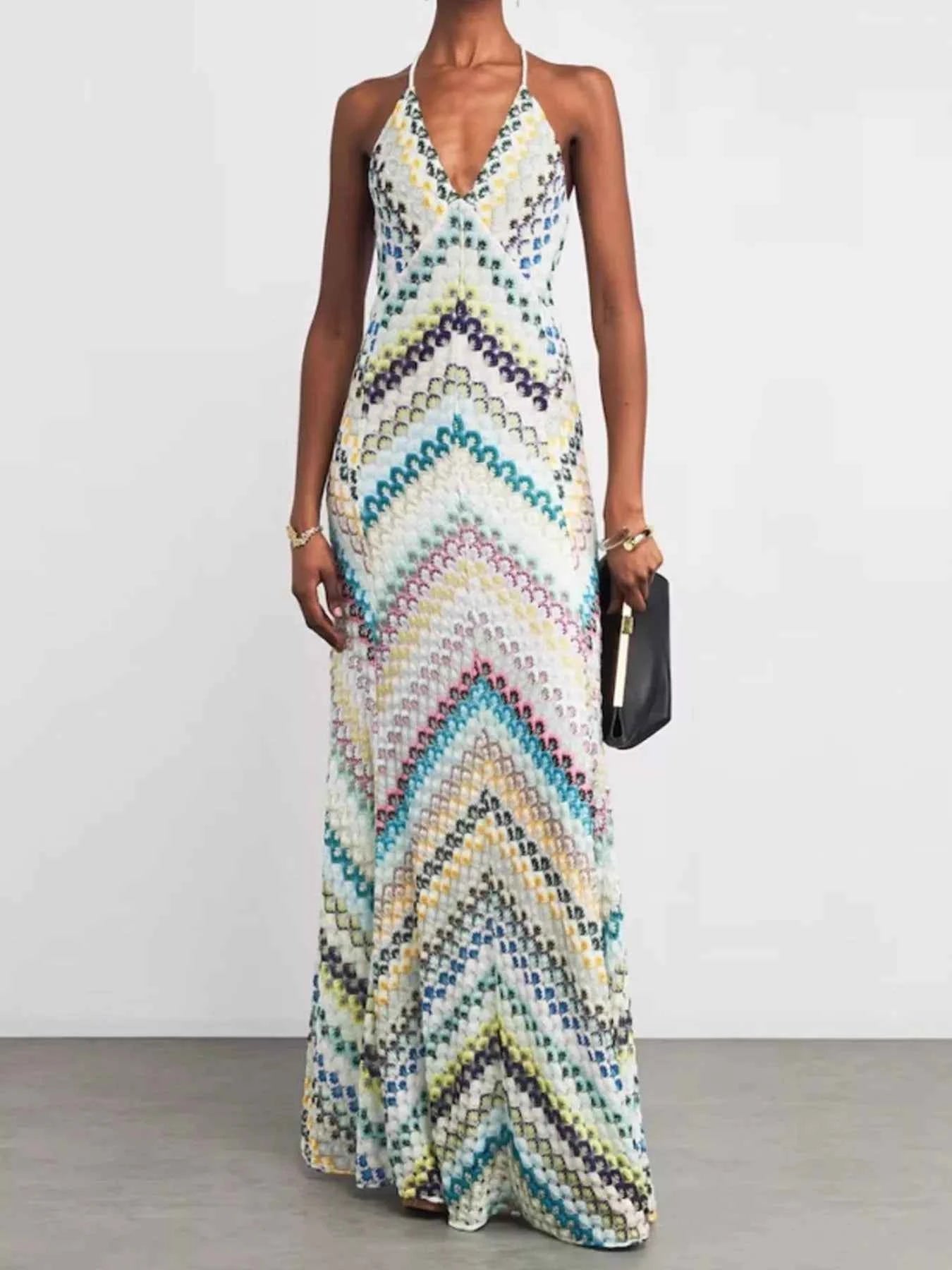 Woman wearing a colorful zigzag patterned dress on a plain background