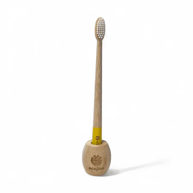 bamboo toothbrush in minimalist wooden stand
