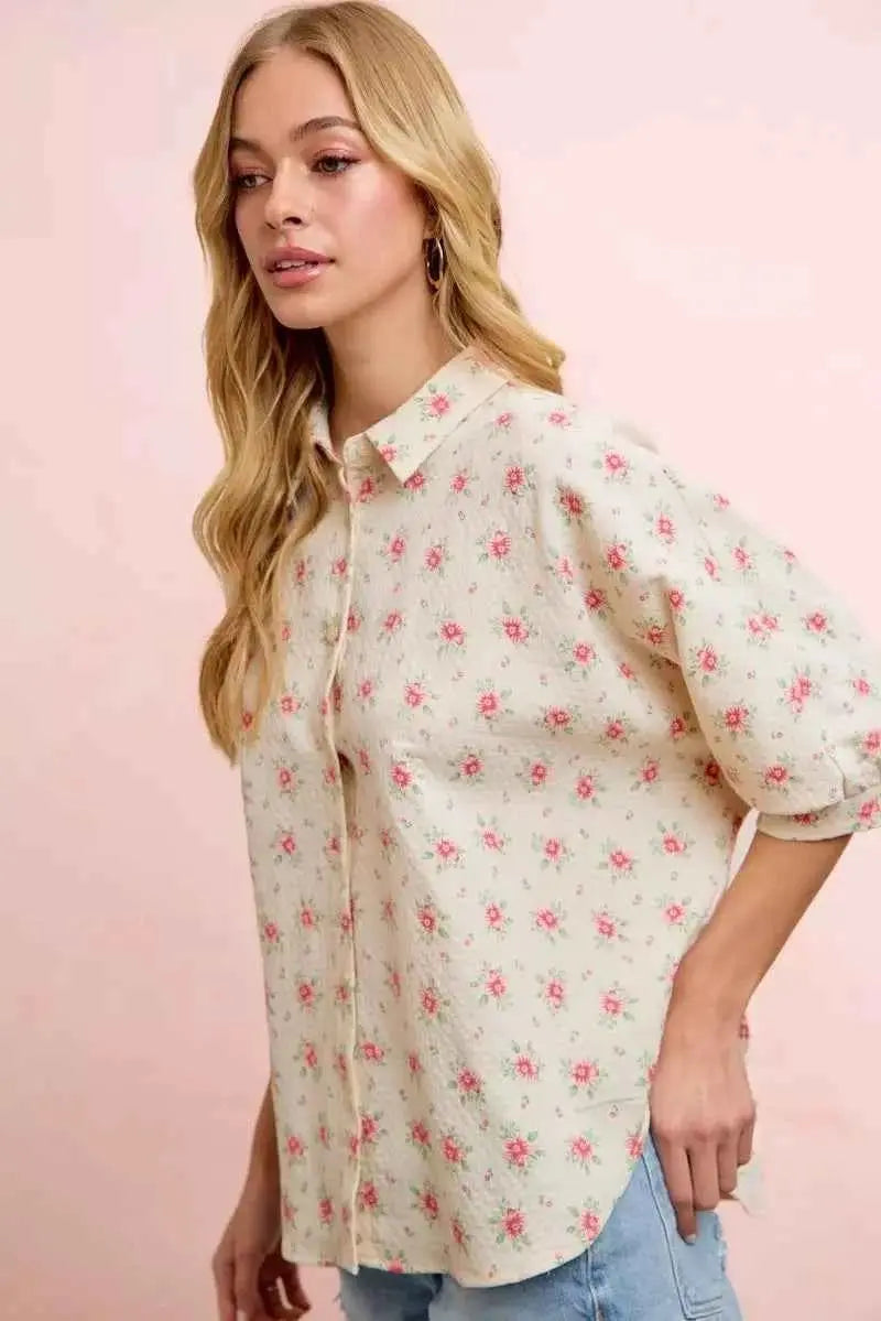 Woman wearing a floral blouse against a pink background