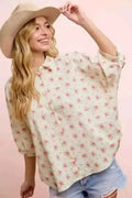 Woman wearing a floral blouse with pink ground.