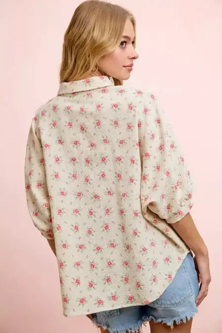 Woman wearing a floral blouse with a pink background