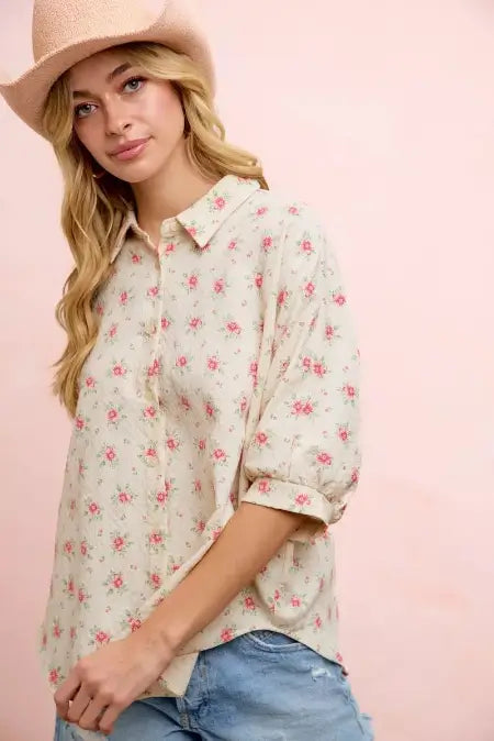 Woman wearing a floral blouse and hat against a pink background