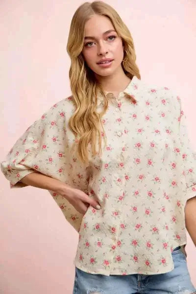 Woman wearing a floral blouse with a pink background