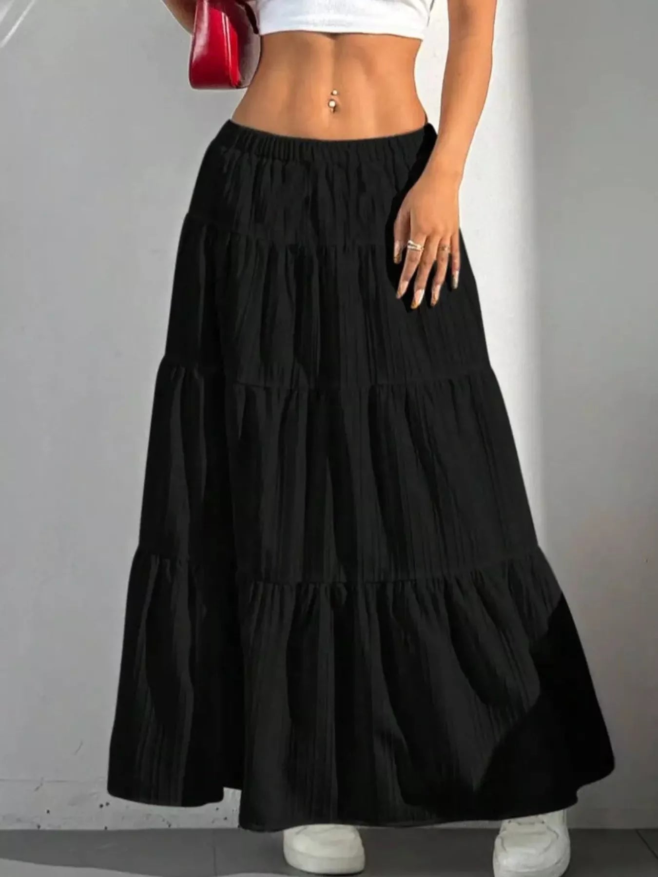 Black tiered maxi skirt with shadow on white wall