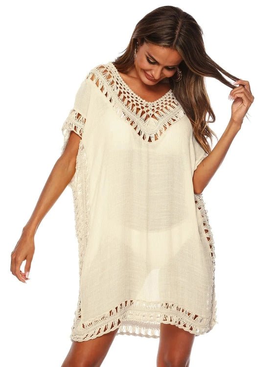 Woman looking at the floor wearing a white crochet cover-up dress on a white  background