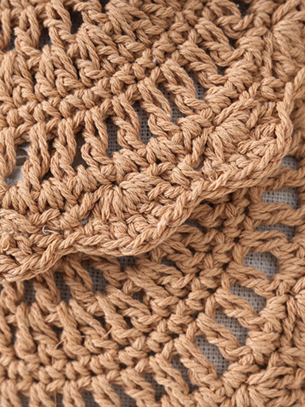 Close-up of a brown crocheted fabric with a textured pattern