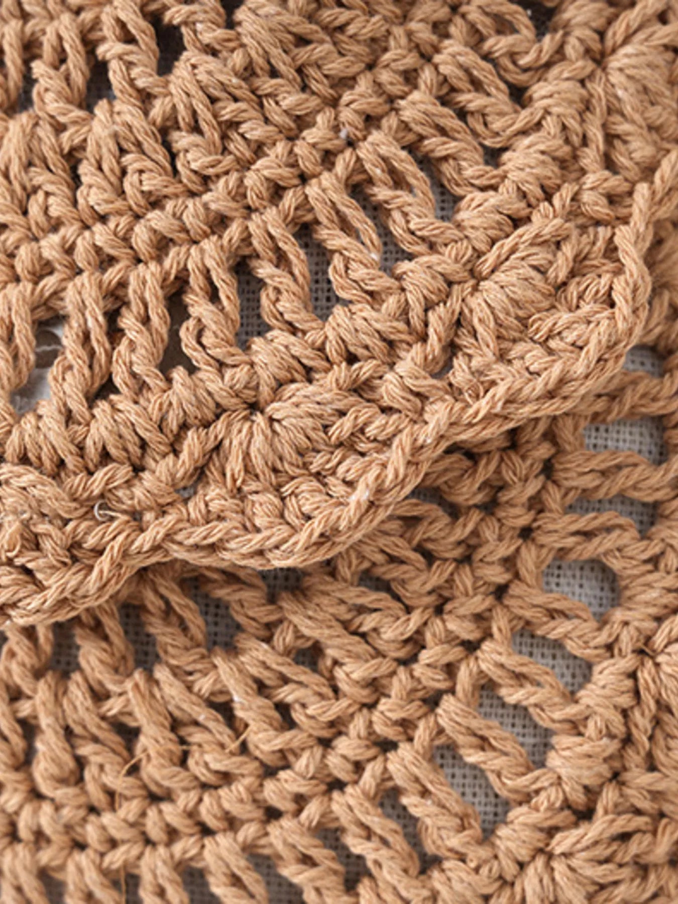 Close-up of a brown crocheted fabric with a textured pattern