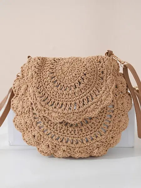 Brown crochet handbag on a white surface with a beige background