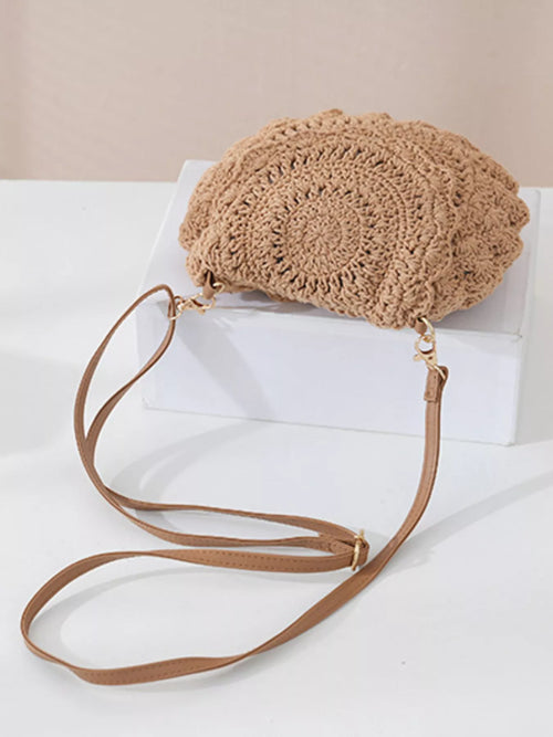 Beige crochet handbag with a strap on a white surface