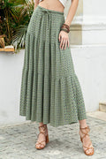 Person wearing a green patterned skirt standing outdoors.