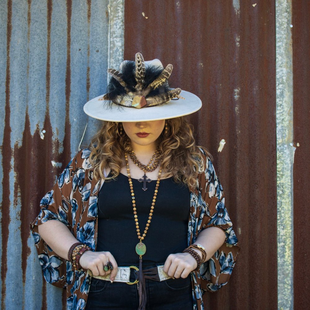 Person wearing a decorative hat and patterned kimono against a rusty metal wall