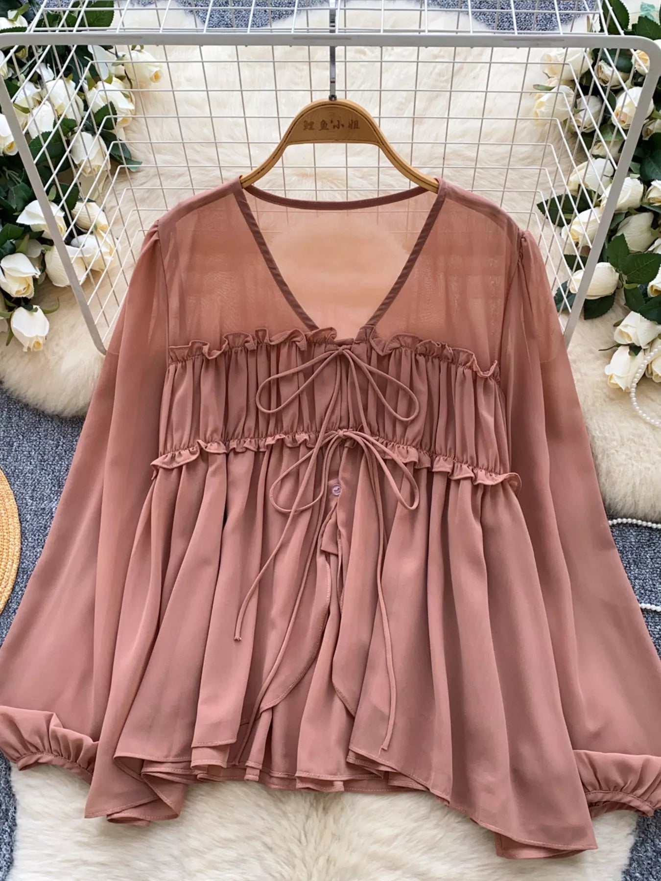 Brown blouse on a hanger with decorative background