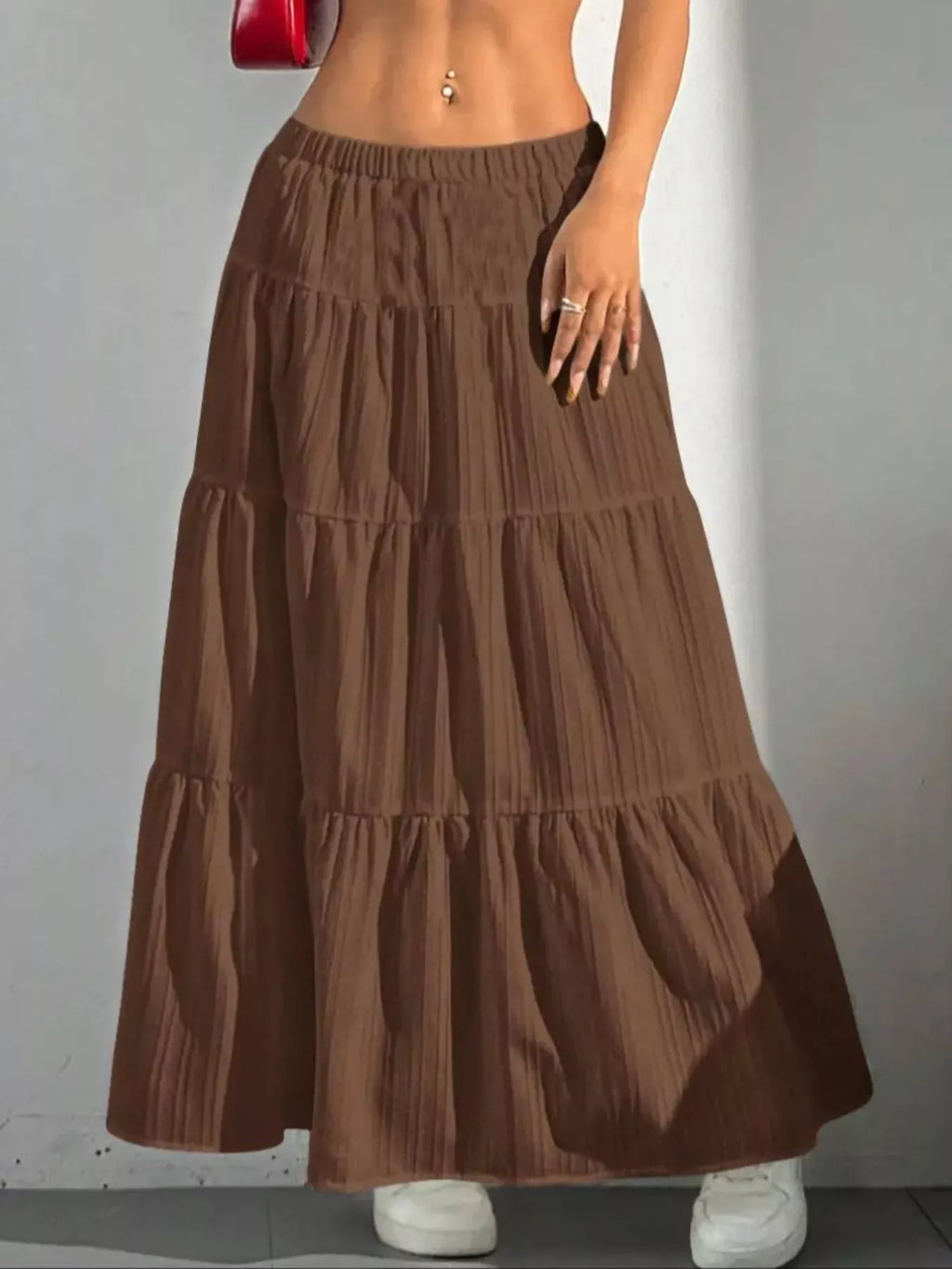 Brown tiered maxi skirt with shadow on white wall