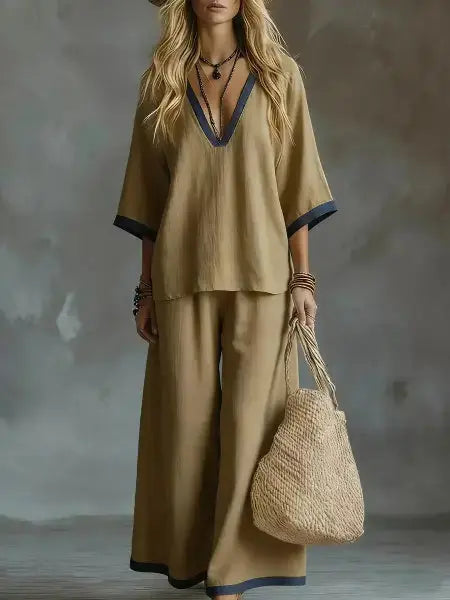 Woman in a beige outfit holding a woven bag against a textured gray background