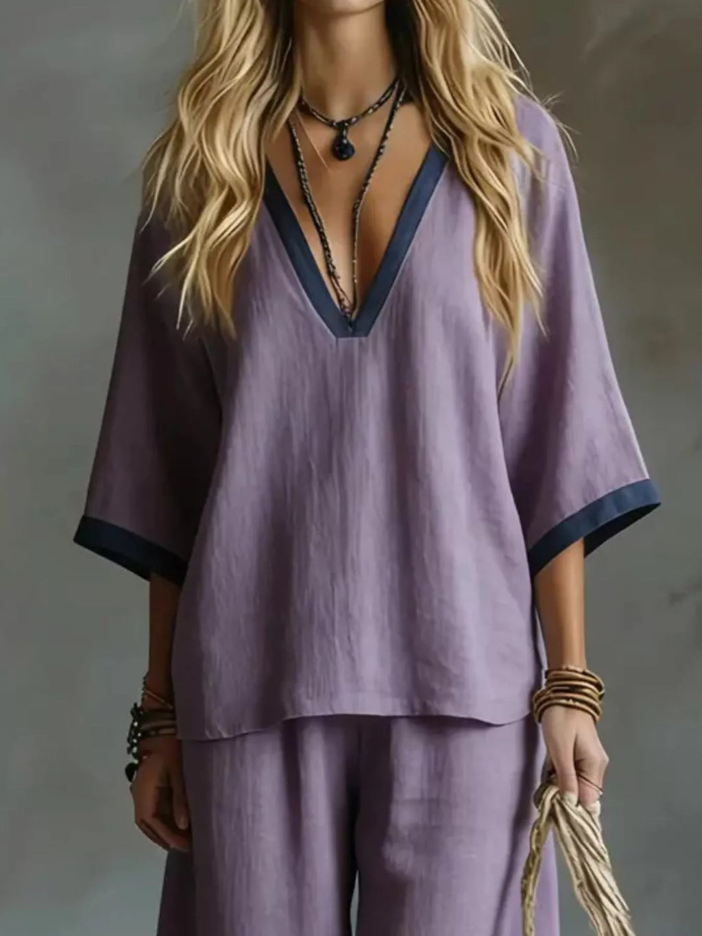 Person wearing a purple outfit with a deep neckline against a neutral background