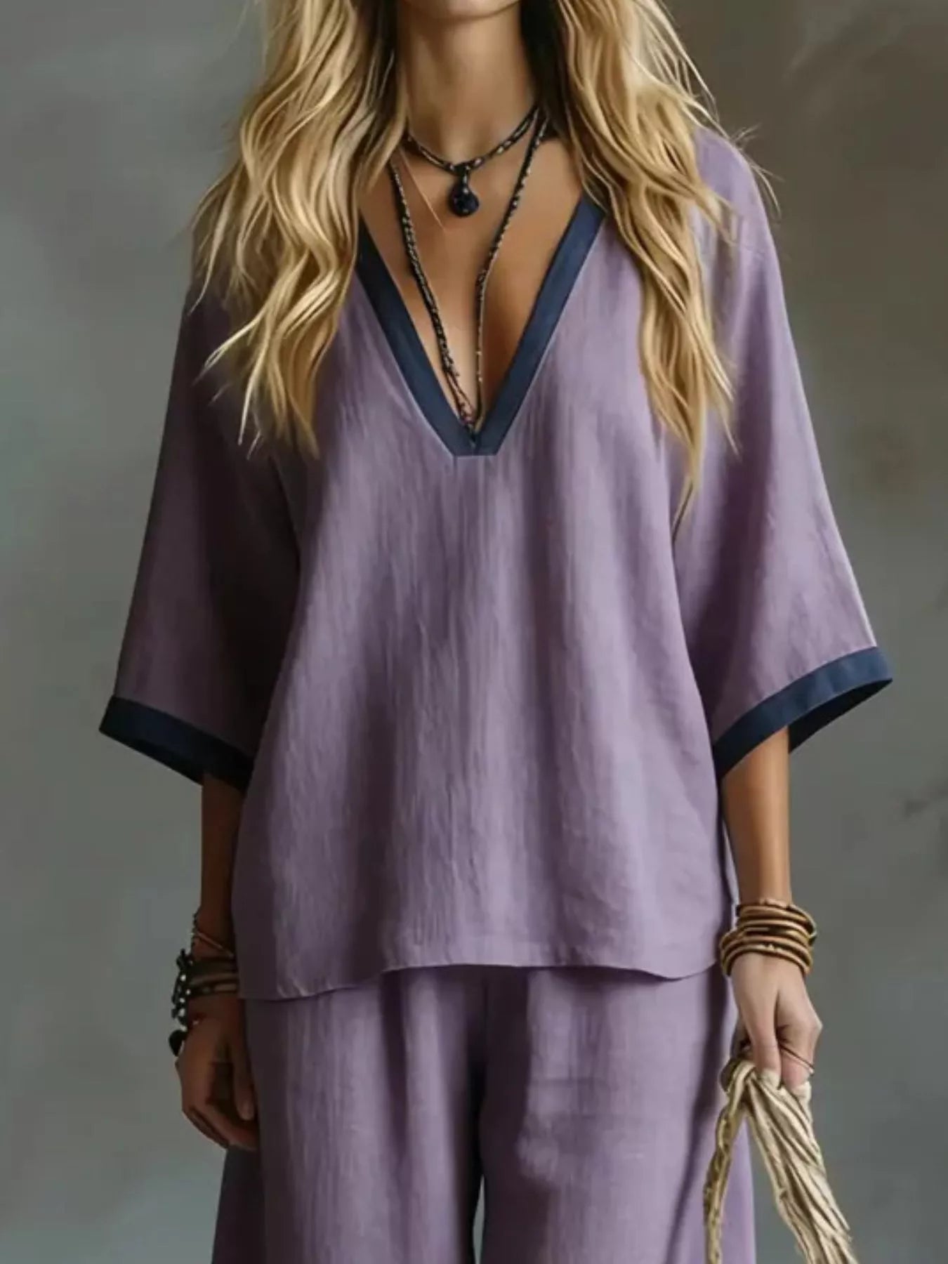 Person wearing a purple outfit with a deep neckline against a neutral background