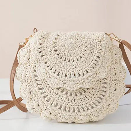 Crocheted handbag with brown straps on a light background