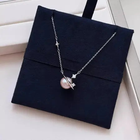 Pearl pendant necklace with two star charms on velvet pouch
