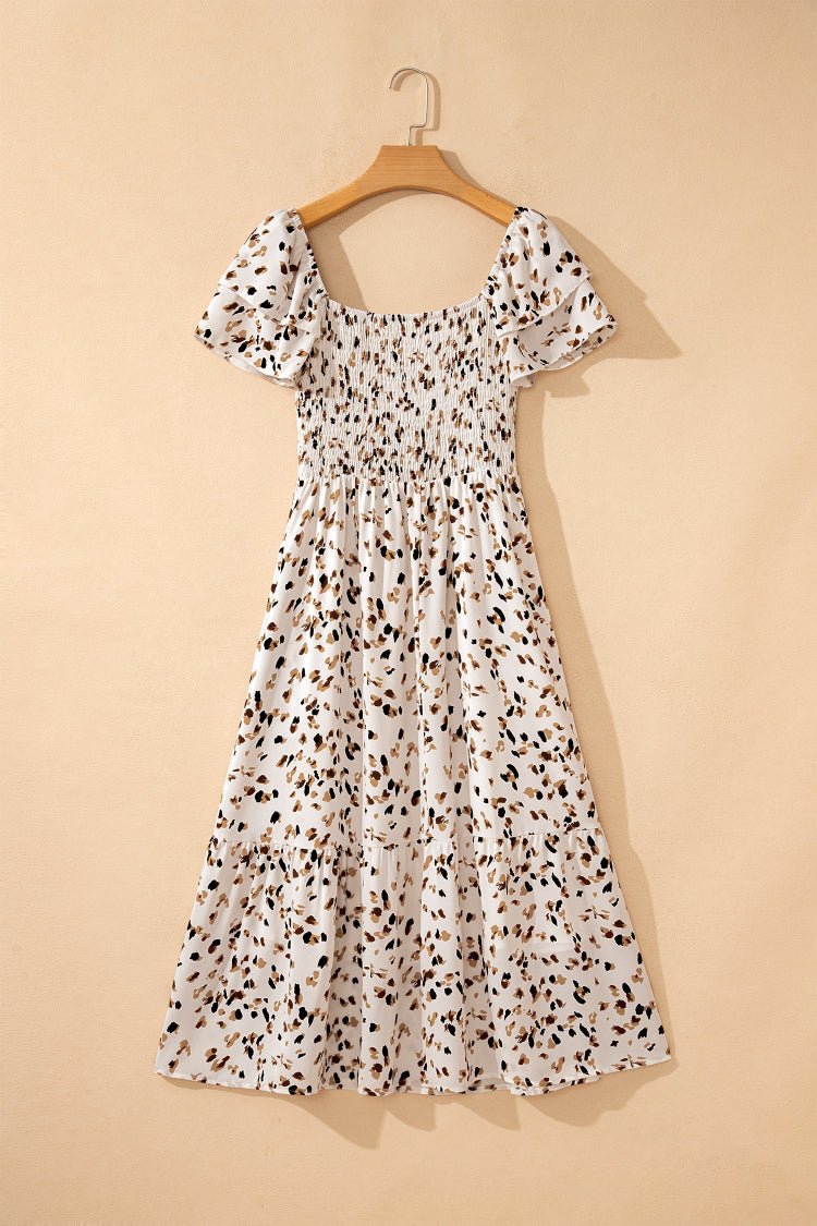 Floral dress on a wooden hanger against a beige background