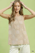 Woman wearing a beige lace top against a light green background