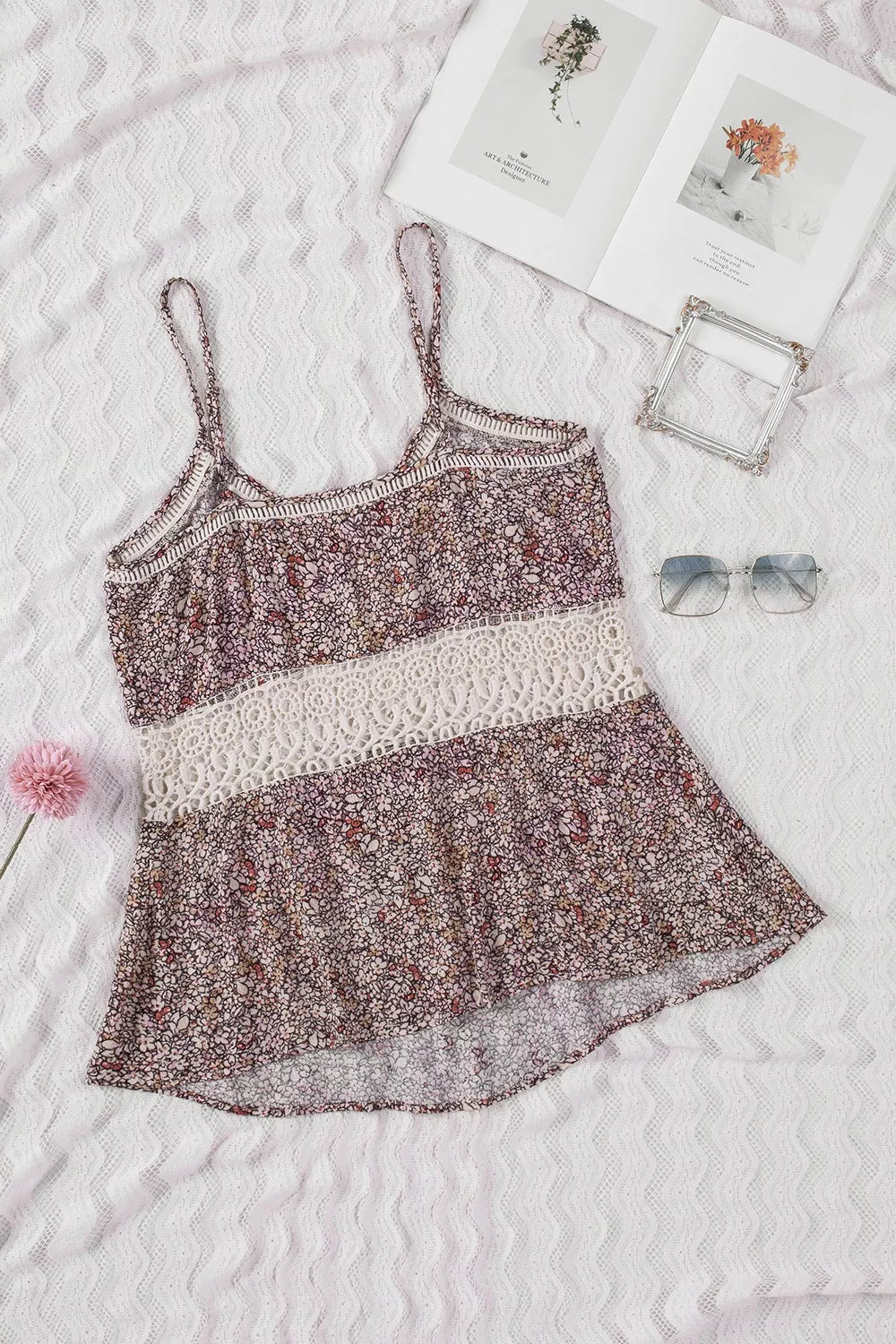 Floral patterned camisole on a textured white surface with decorative items.
