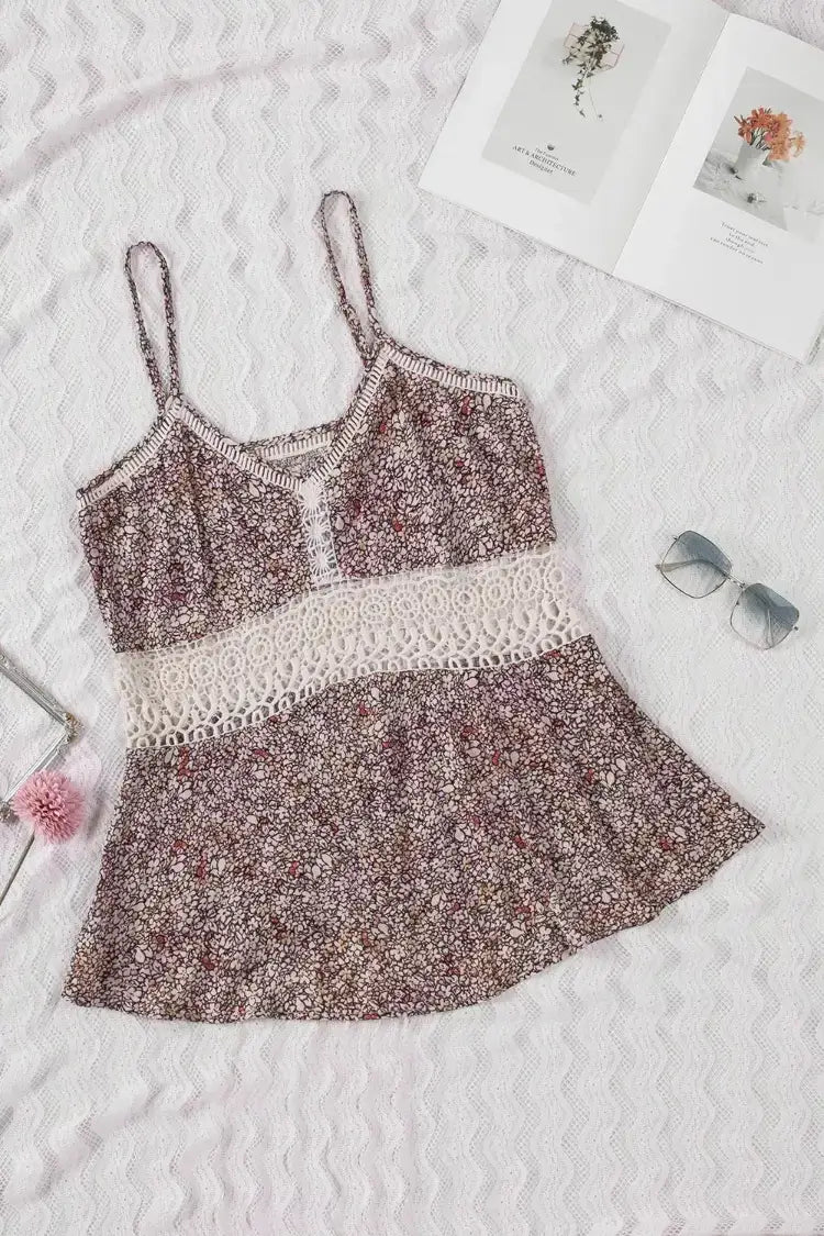 Floral dress with lace details on a textured surface with sunglasses and pink flower.