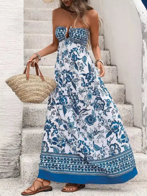 Woman wearing a blue and white floral dress standing on stone steps.