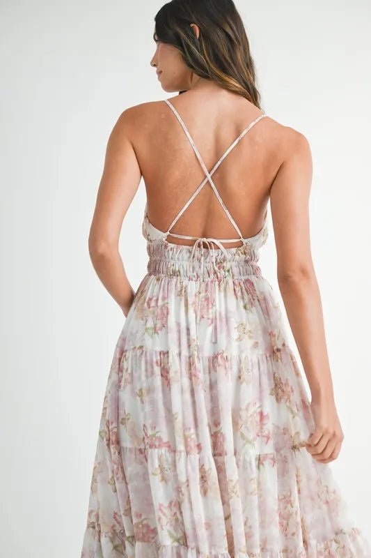 Woman wearing a floral dress with an open back on a white background