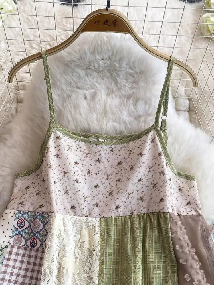 Patchwork dress with floral and lace details on a hanger against a textured wall.