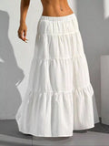White tiered skirt worn by a person against a neutral background