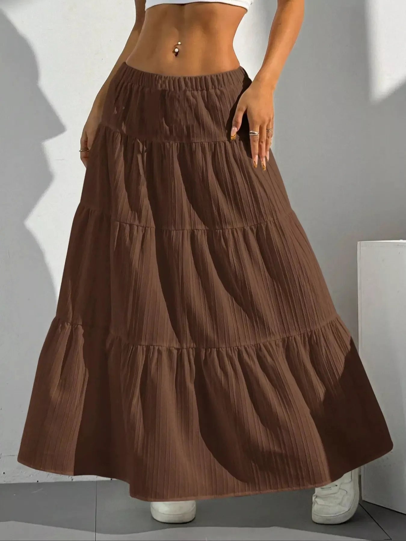Brown tiered maxi skirt with shadow on white wall