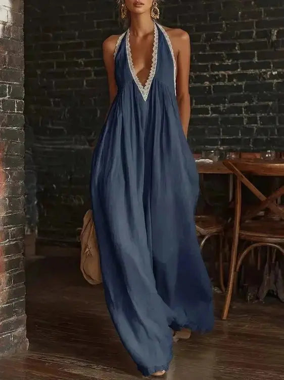 Navy blue halter neck jumpsuit with white lace trim and flowing fabric