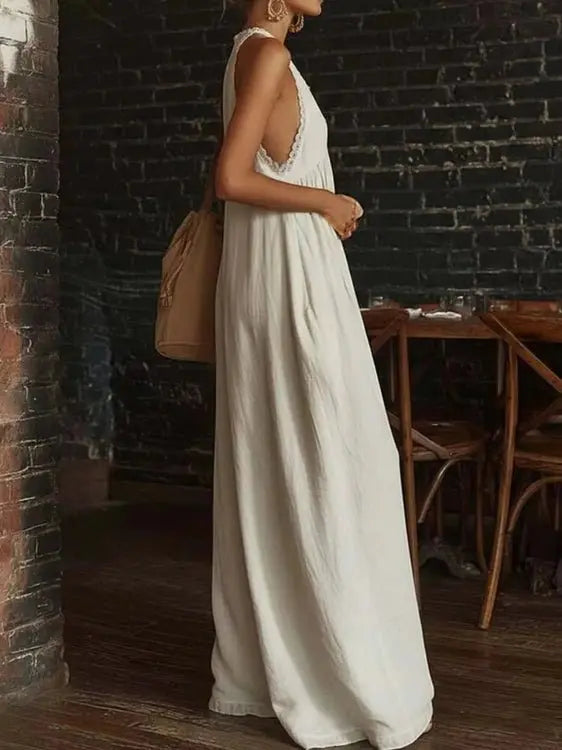 Side profile of white halter jumpsuit showing lace trim and drape
