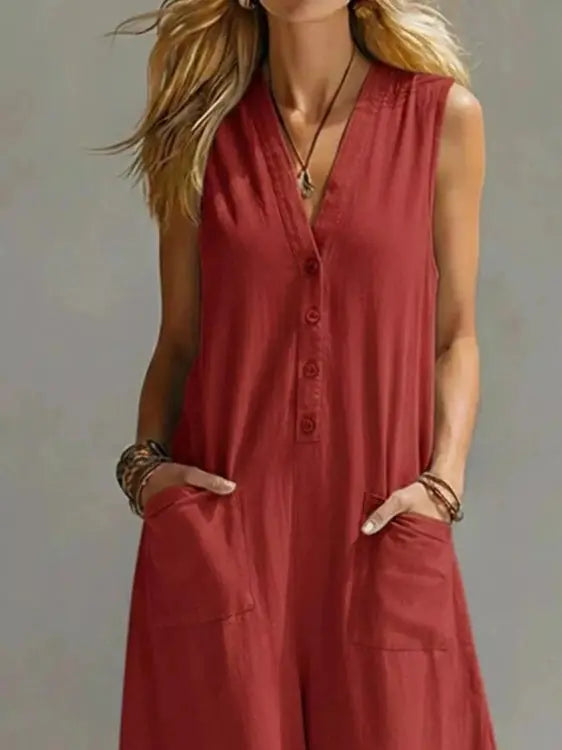 Close-up of rust red V-neck sleeveless jumpsuit showing fabric texture and patch pockets