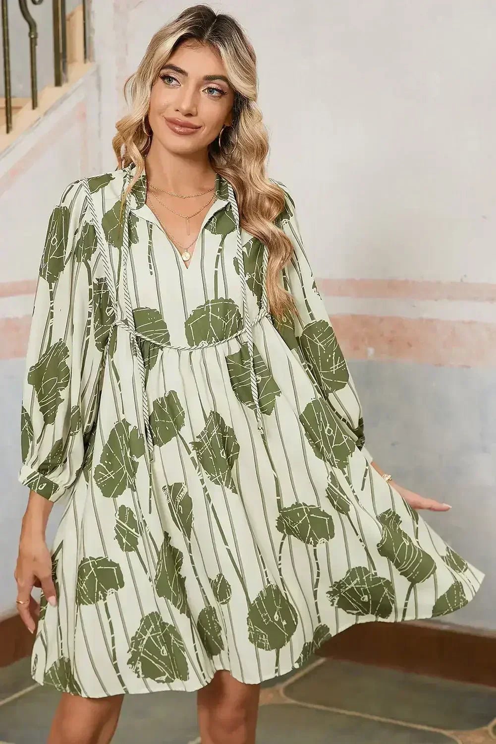 Woman wearing a green and white patterned dress indoors.