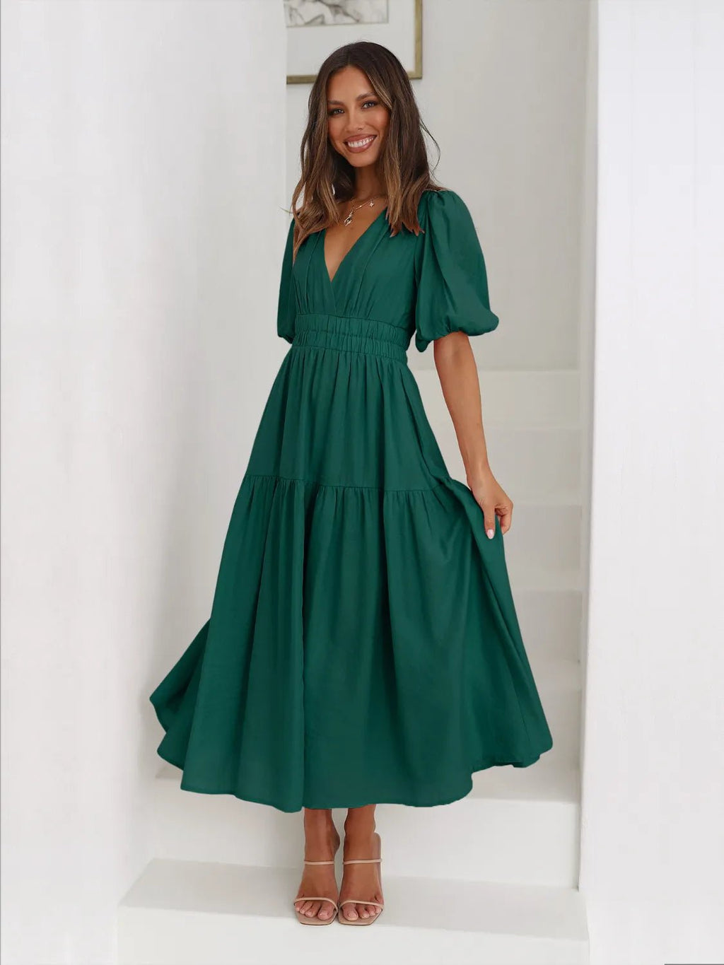 Woman wearing a green dress in a minimal white room