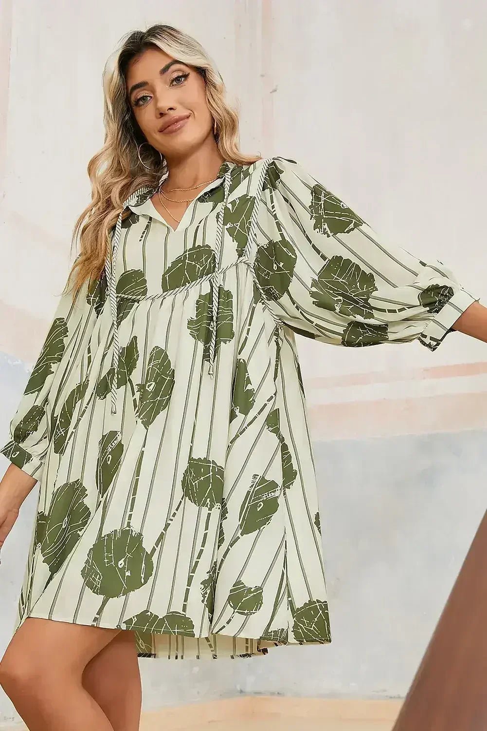 Woman wearing a green leaf-patterned dress against a neutral background