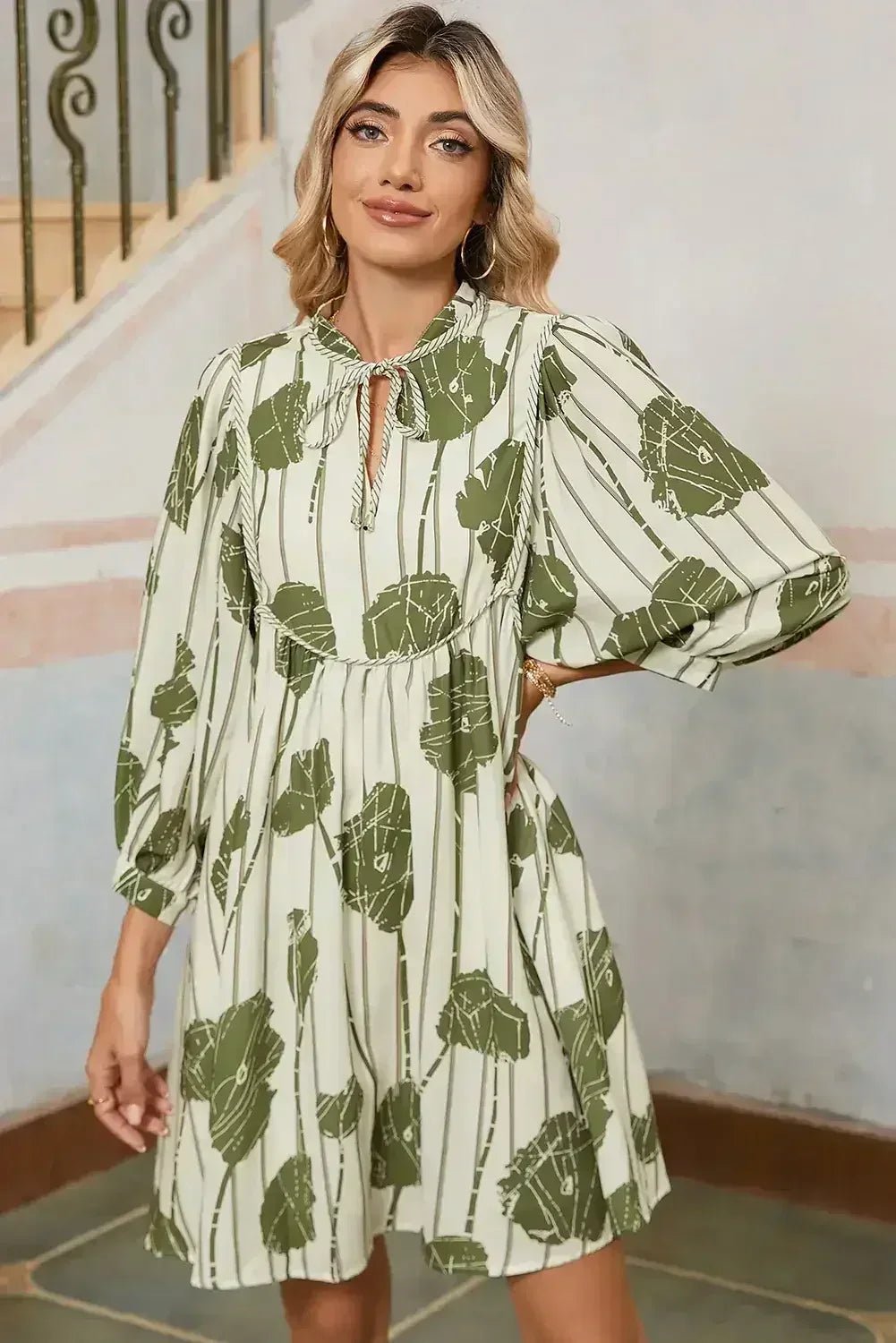 Woman wearing a green and white leaf-patterned dress indoors.